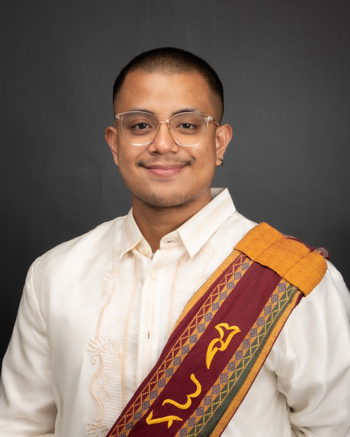 Portrait of Lars Lenon wearing a barong and UP sablay